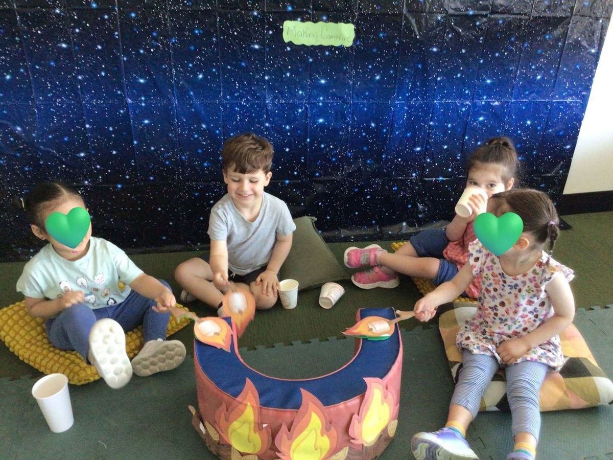 Children gathered around a pretend campfire during dramatic play at Park View Academy