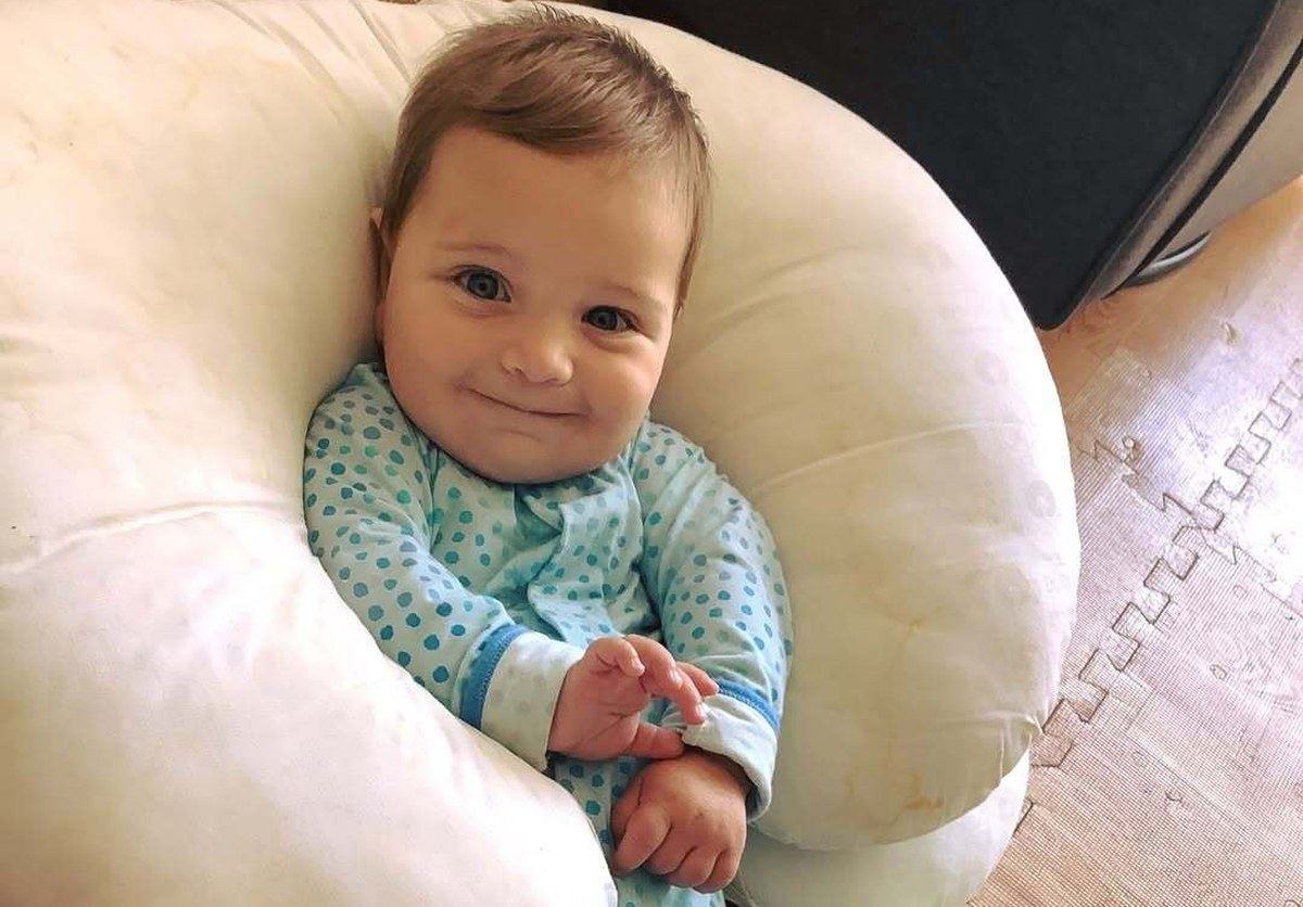 Smiling infant supported by a nursing pillow at Park View Academy