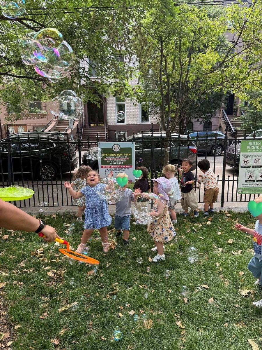 Children chasing bubbles at a Jersey City park with Park View Academy