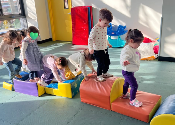 Toddlers climbing on soft play equipment at Park View Academy